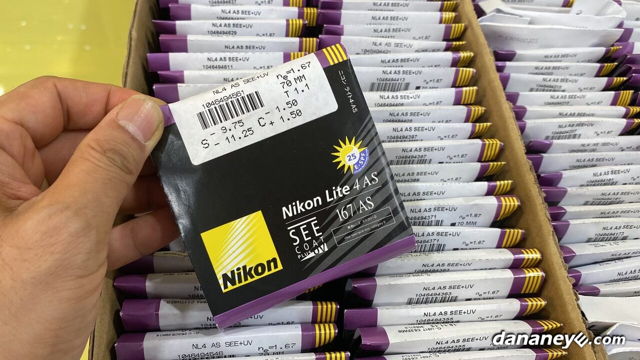 手拿 Nikon Lite 4AS 原廠包裝的鏡片，後面是整盒原廠包裝