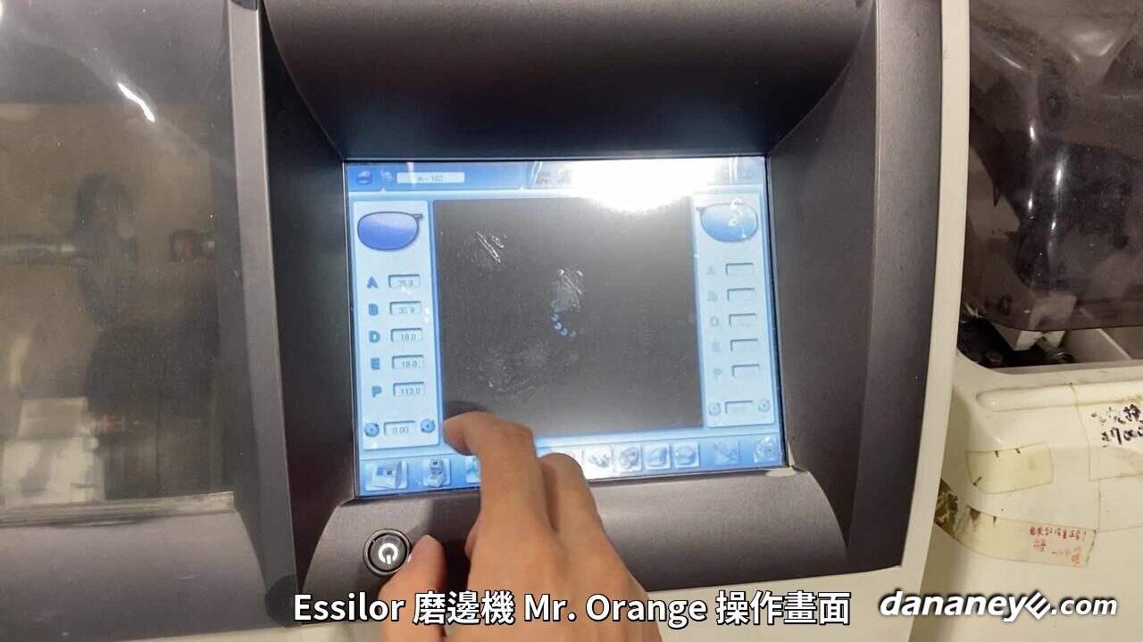 Essilor 磨邊機 Mr. Orange 的操作畫面,驗光師正在按螢幕操作 Essilor 磨邊機 Mr. Orange 的操作畫面,驗光師正在按螢幕操作